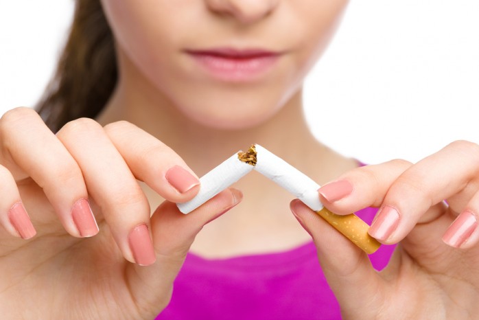 Young woman breaking a cigarette